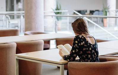 woman reading a book at a table